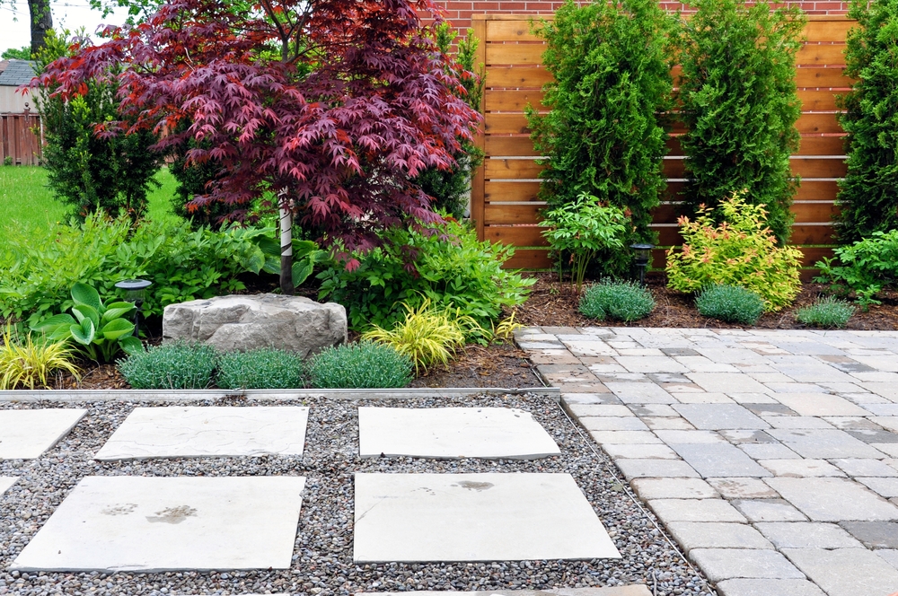 Detail of a Beautiful Modern Asian Inspired Japanese Garden with Tumbled Paver Patio Flagstone Walkway and Horizontal Cedar Fence in an Urban Backyard