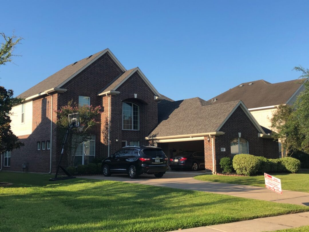 New roof on a two-story brick home with a steep pitch