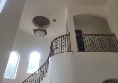 Curved Staircase with Wrought Iron Balusters