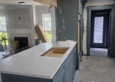 Kitchen with Green Cabinetry and White Quartz Island